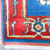 Close-up of a colorful patterned rug with red, blue, and white colors.