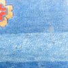 Close-up of a textured blue surface with a red and yellow object in the corner