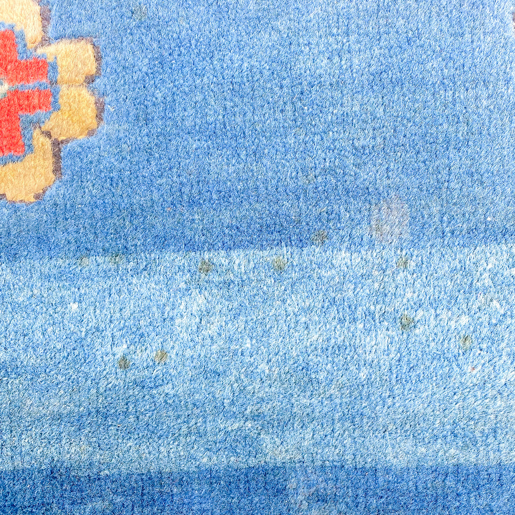 Close-up of a textured blue surface with a red and yellow object in the corner