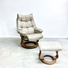 Beige leather recliner chair with ottoman on a light gray floor.