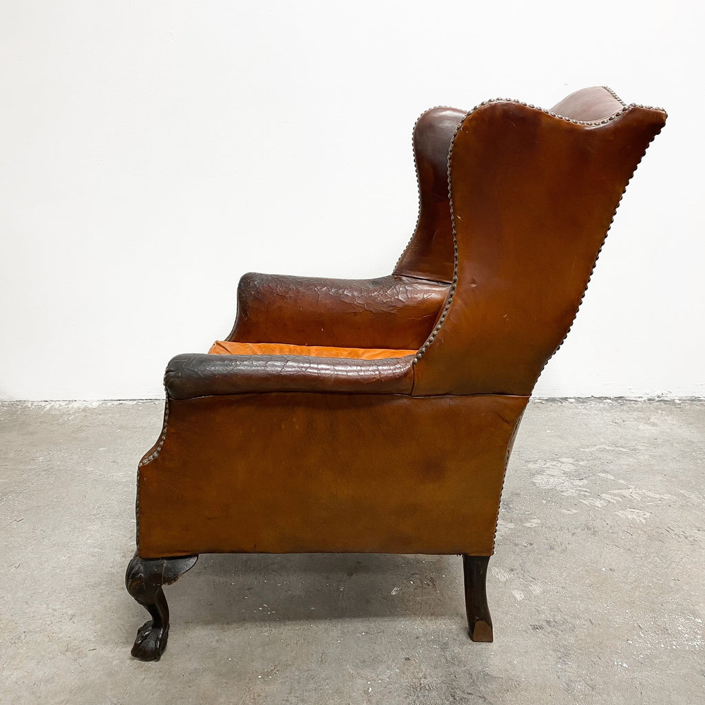 Distressed antique Georgian leather wingback armchair