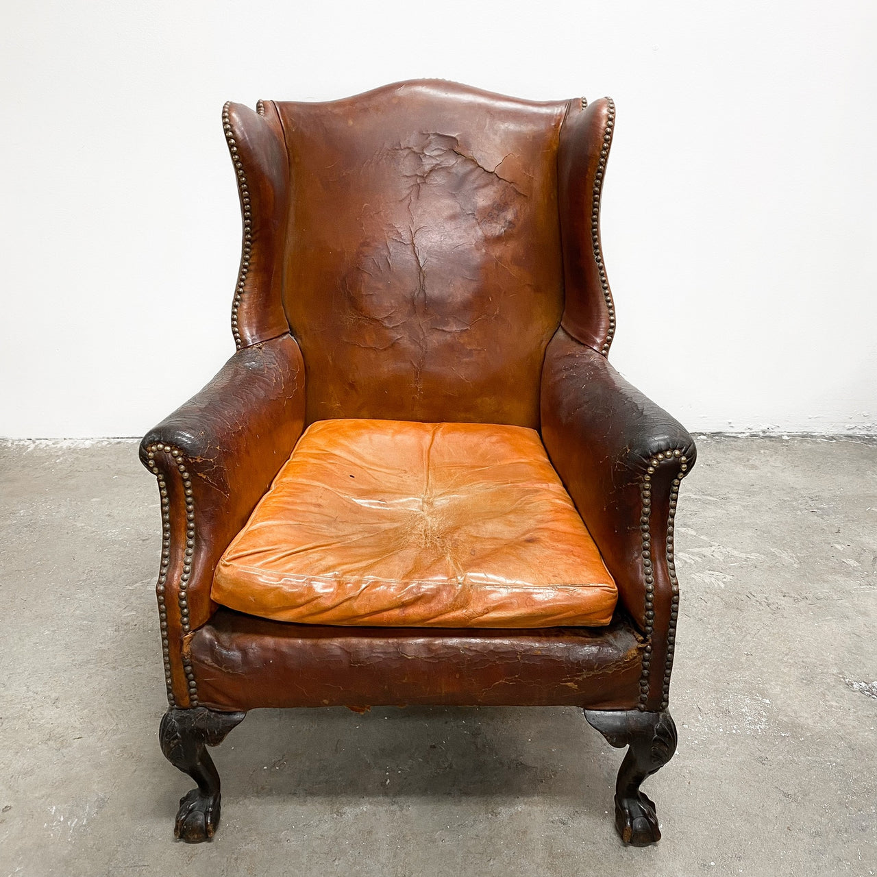 Distressed antique Georgian leather wingback armchair