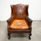 Distressed antique Georgian leather wingback armchair