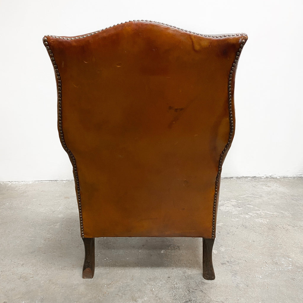 Distressed antique Georgian leather wingback armchair